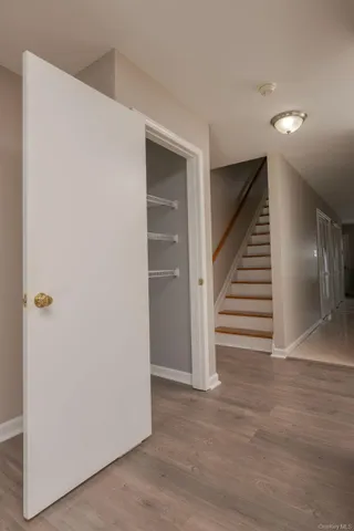 a view of a hallway with wooden floor and stairs