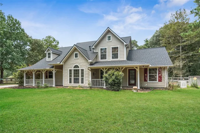 a front view of a house with a yard and trees