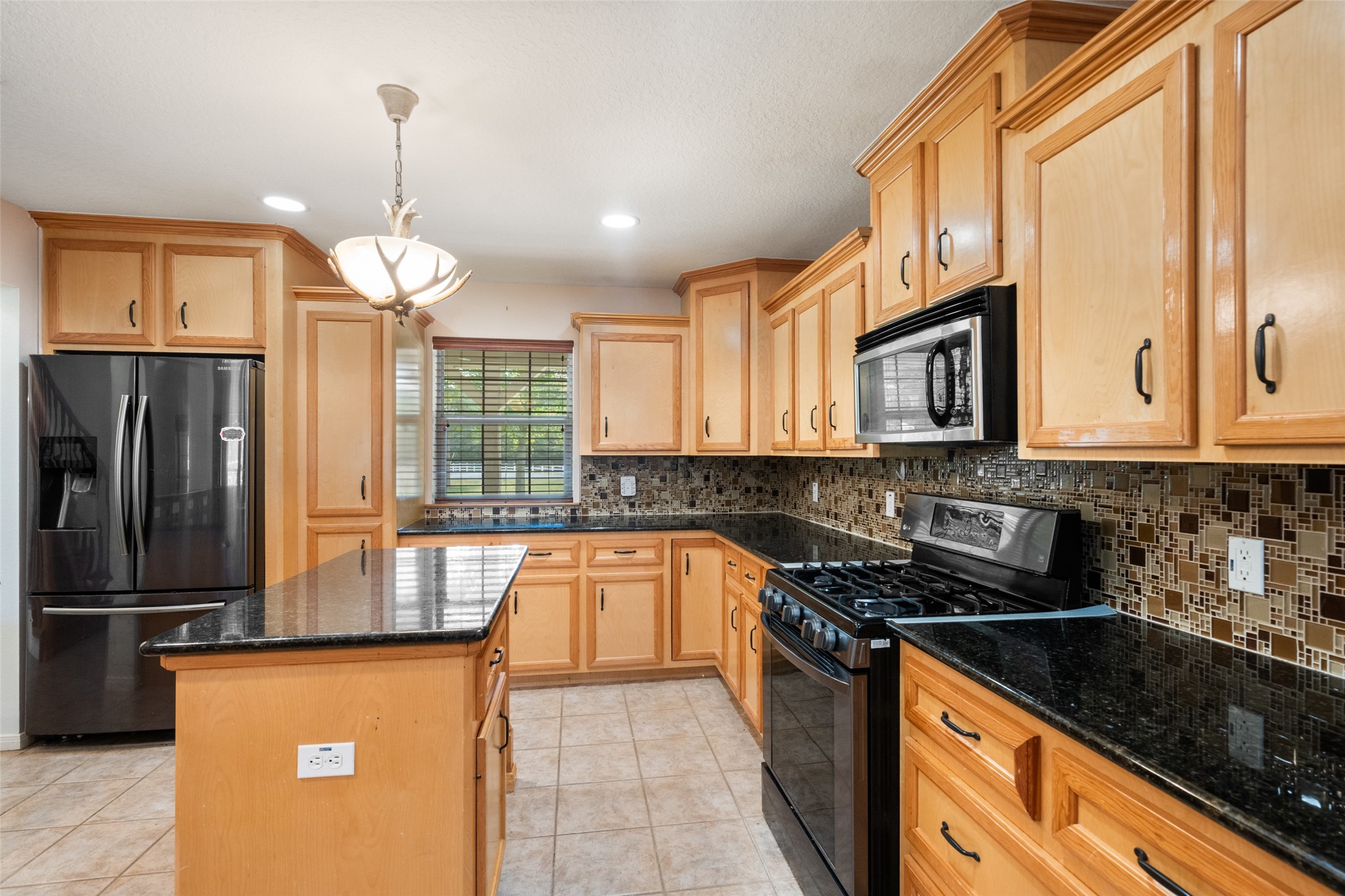 7863 Rodeo Road Waller, TX 77484 - Photo 12 of 36 a kitchen with stainless steel appliances granite countertop a sink a stove and a refrigerator