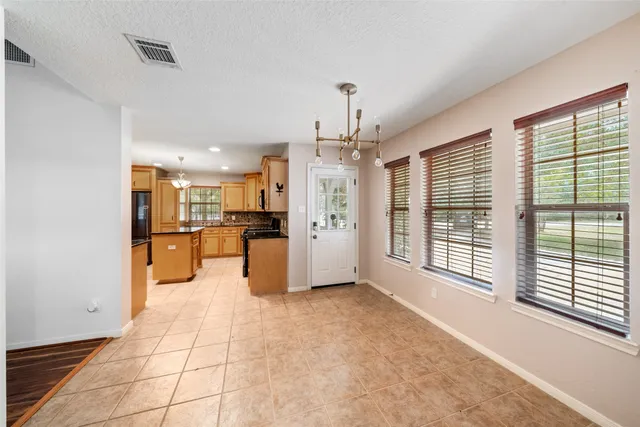 a view of a kitchen with refrigerator and windows