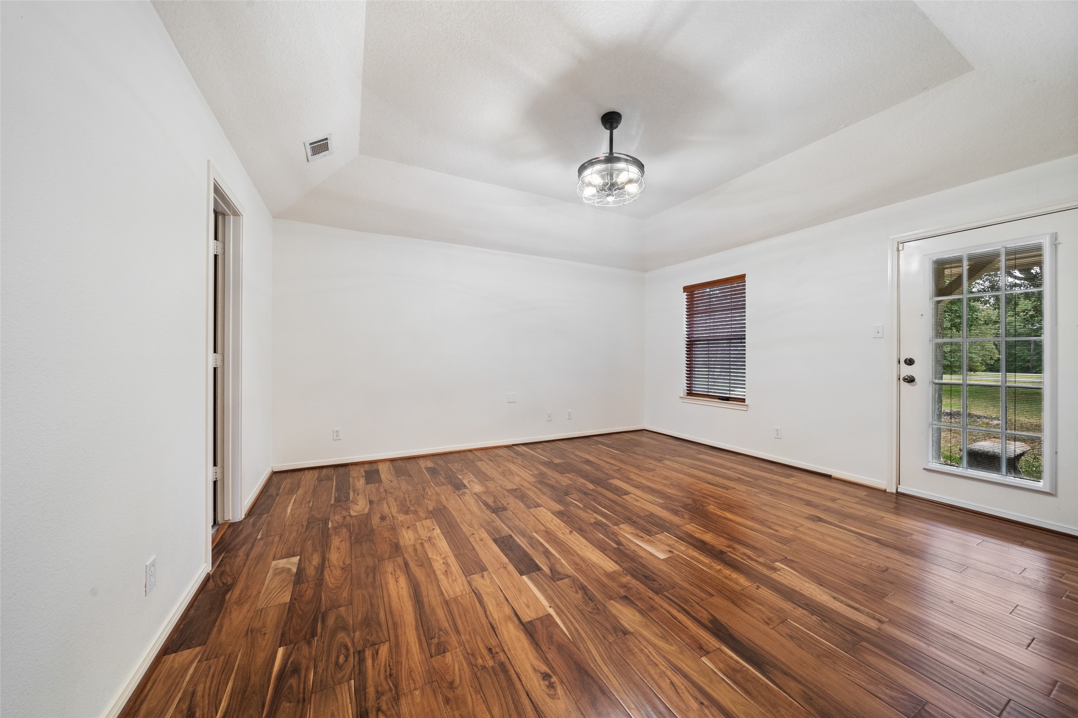 7863 Rodeo Road Waller, TX 77484 - Photo 19 of 36 a view of empty room with wooden floor and fan