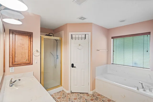 a bathroom with a tub shower and a sink
