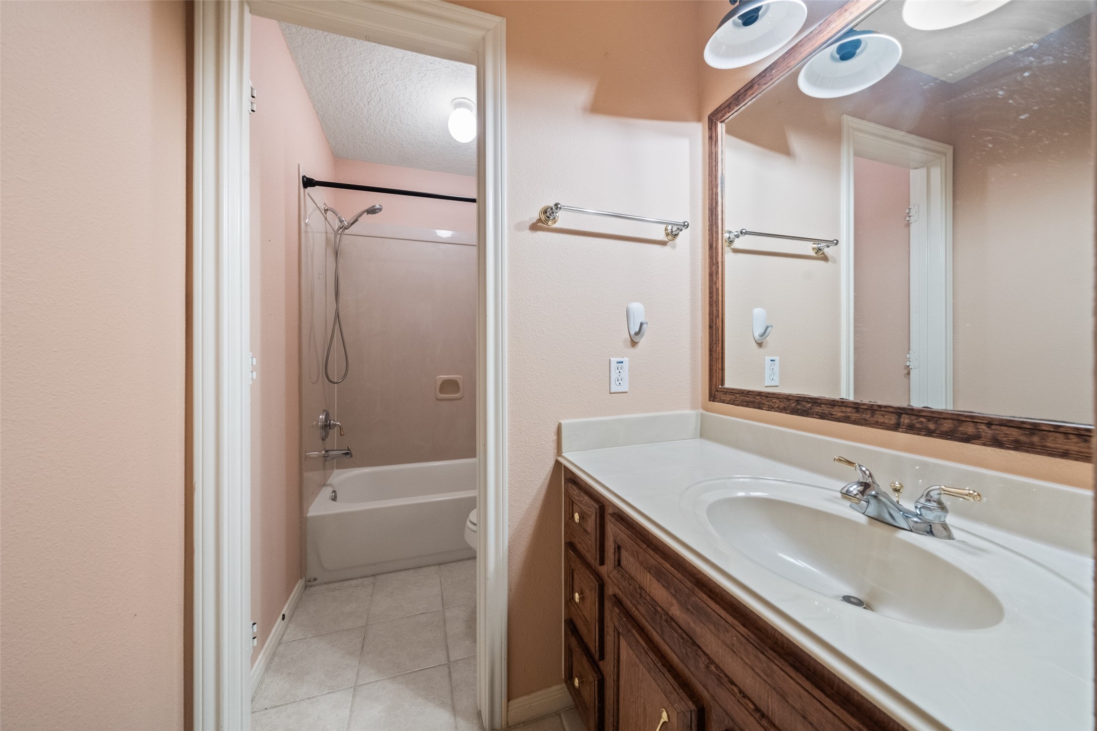 7863 Rodeo Road Waller, TX 77484 - Photo 24 of 36 a bathroom with a granite countertop sink a mirror and a bathtub