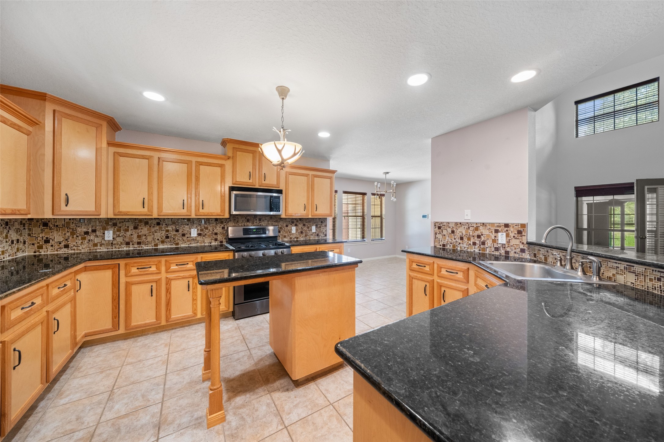 7863 Rodeo Road Waller, TX 77484 - Photo 9 of 36 a kitchen with stainless steel appliances granite countertop a sink counter space cabinets and a stove