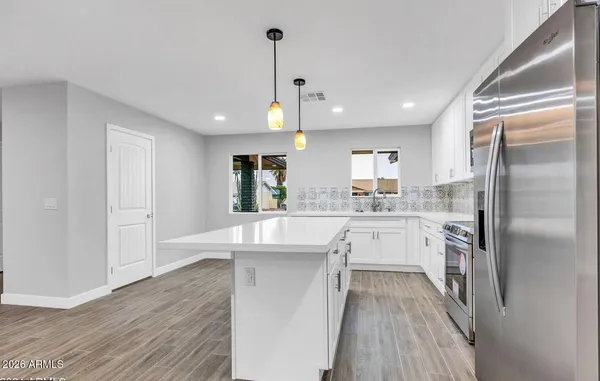 a kitchen with white cabinets and stainless steel appliances