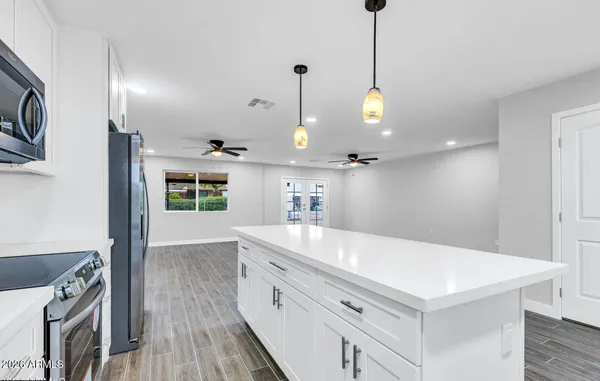 a large kitchen with kitchen island a island a stove a sink a center island and wooden floor
