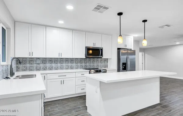 a kitchen with kitchen island a sink stainless steel appliances and cabinets