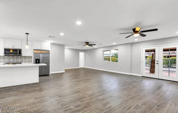 a view of kitchen with stainless steel appliances refrigerator stove microwave and cabinets