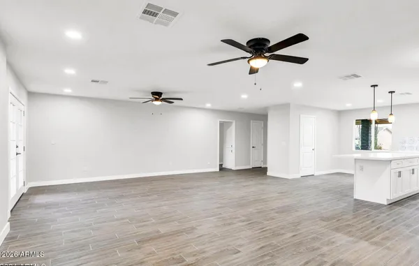 an empty room with fan and windows