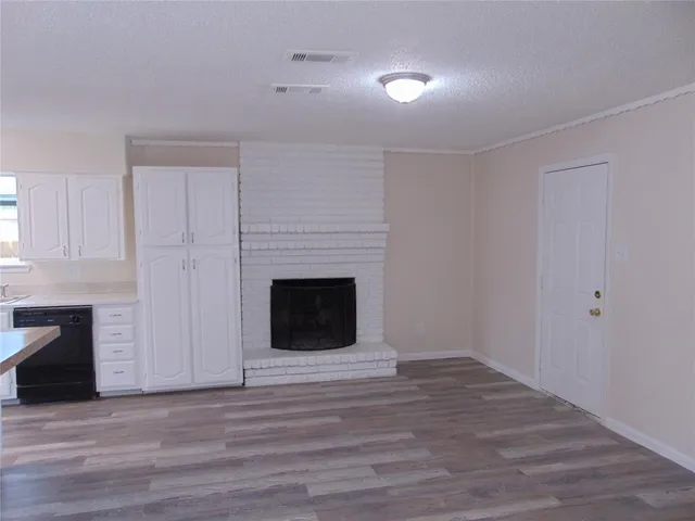 a view of a livingroom with wooden floor and a fireplace