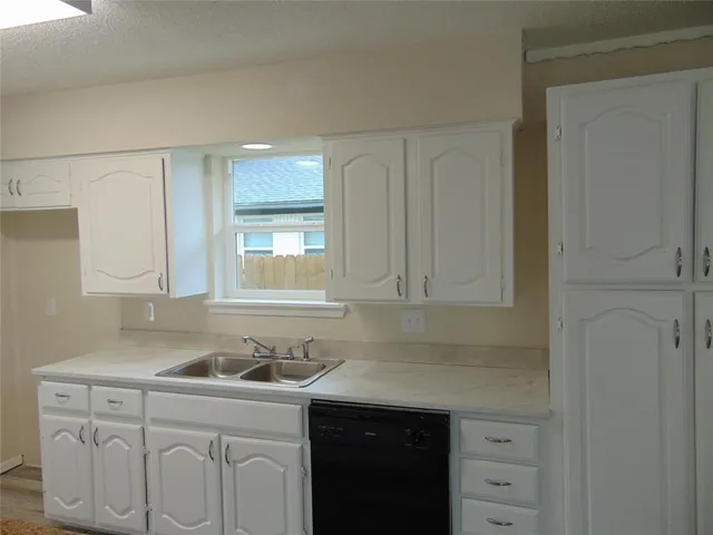 a kitchen with a sink cabinets and window