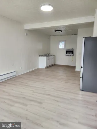 a view of empty room with wooden floor and cabinet