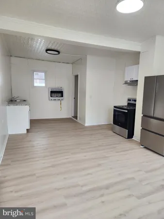 a view of a kitchen with a sink refrigerator and wooden floor