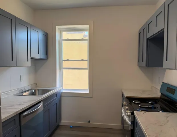 a kitchen with stainless steel appliances granite countertop a sink stove and microwave