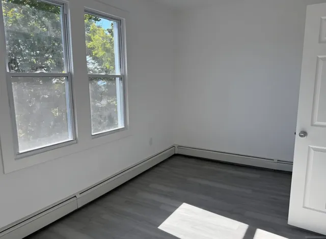 a view of a small space with wooden floor and a window