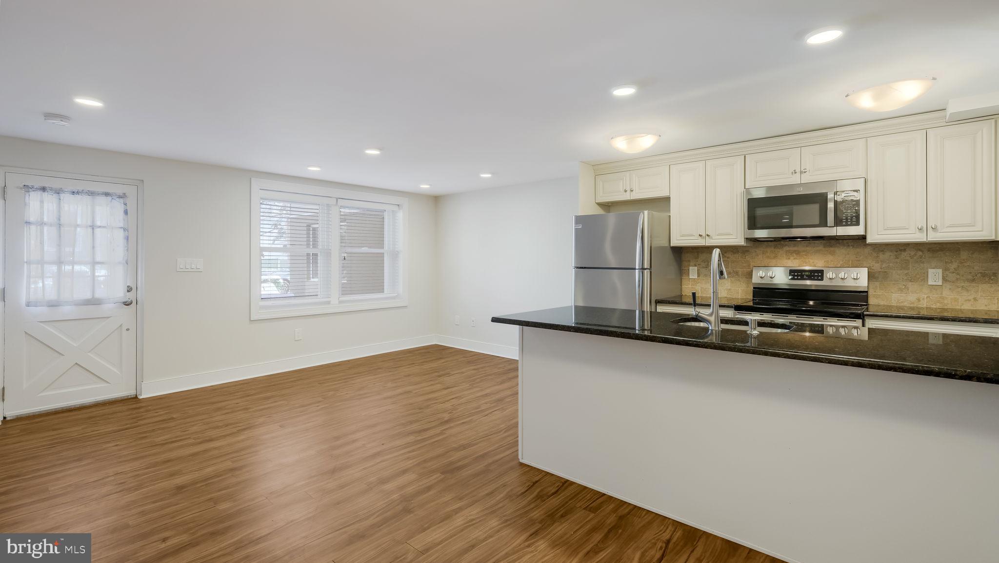 106 East State Street, Unit 4 Doylestown, PA 18901 - Photo 5 of 19 a kitchen with stainless steel appliances a sink a stove a microwave a refrigerator a window and cabinets