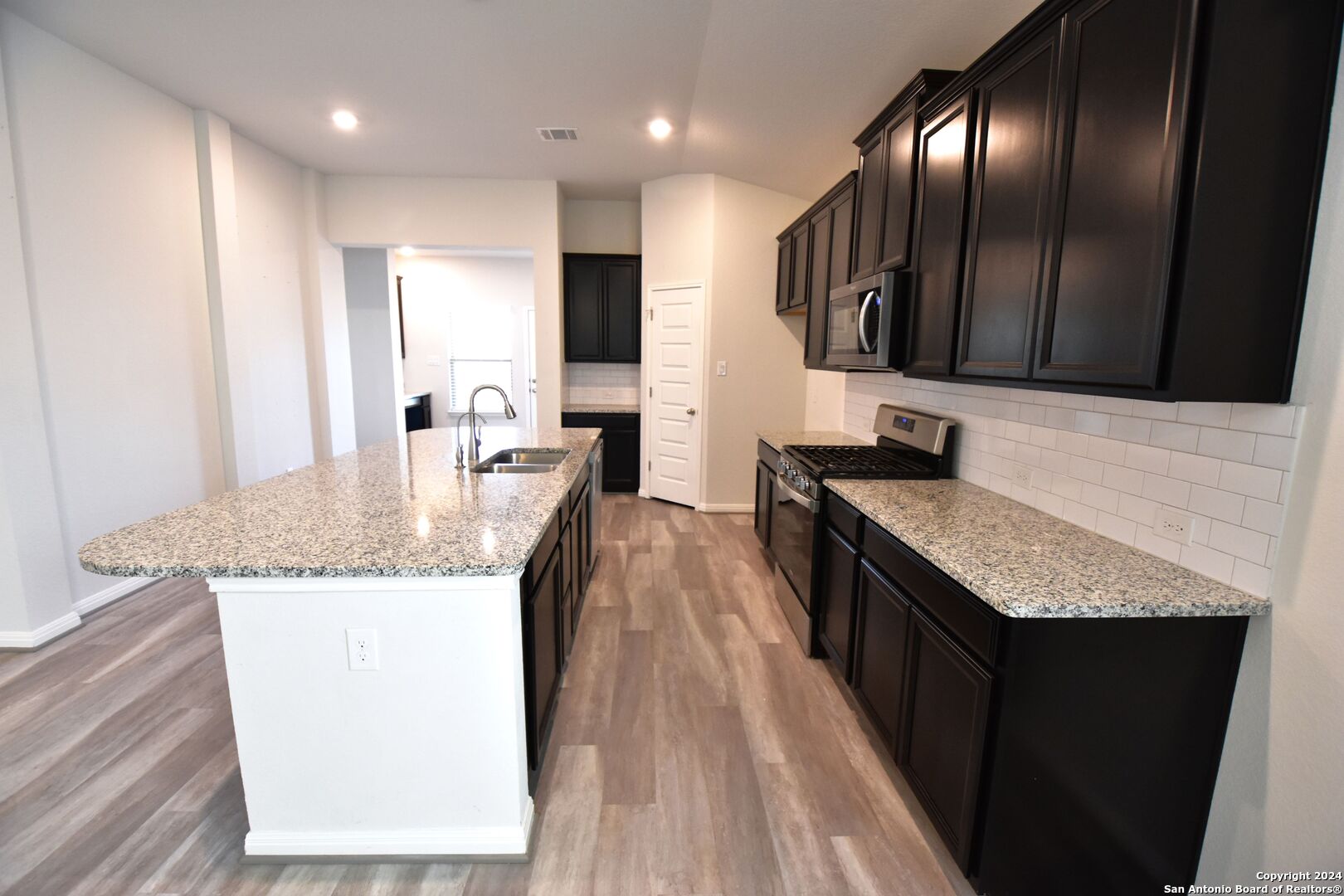 4923 Ranahan Pass St. Hedwig, TX 78152 - Photo 14 of 29 a kitchen with granite countertop stainless steel appliances and wooden cabinets