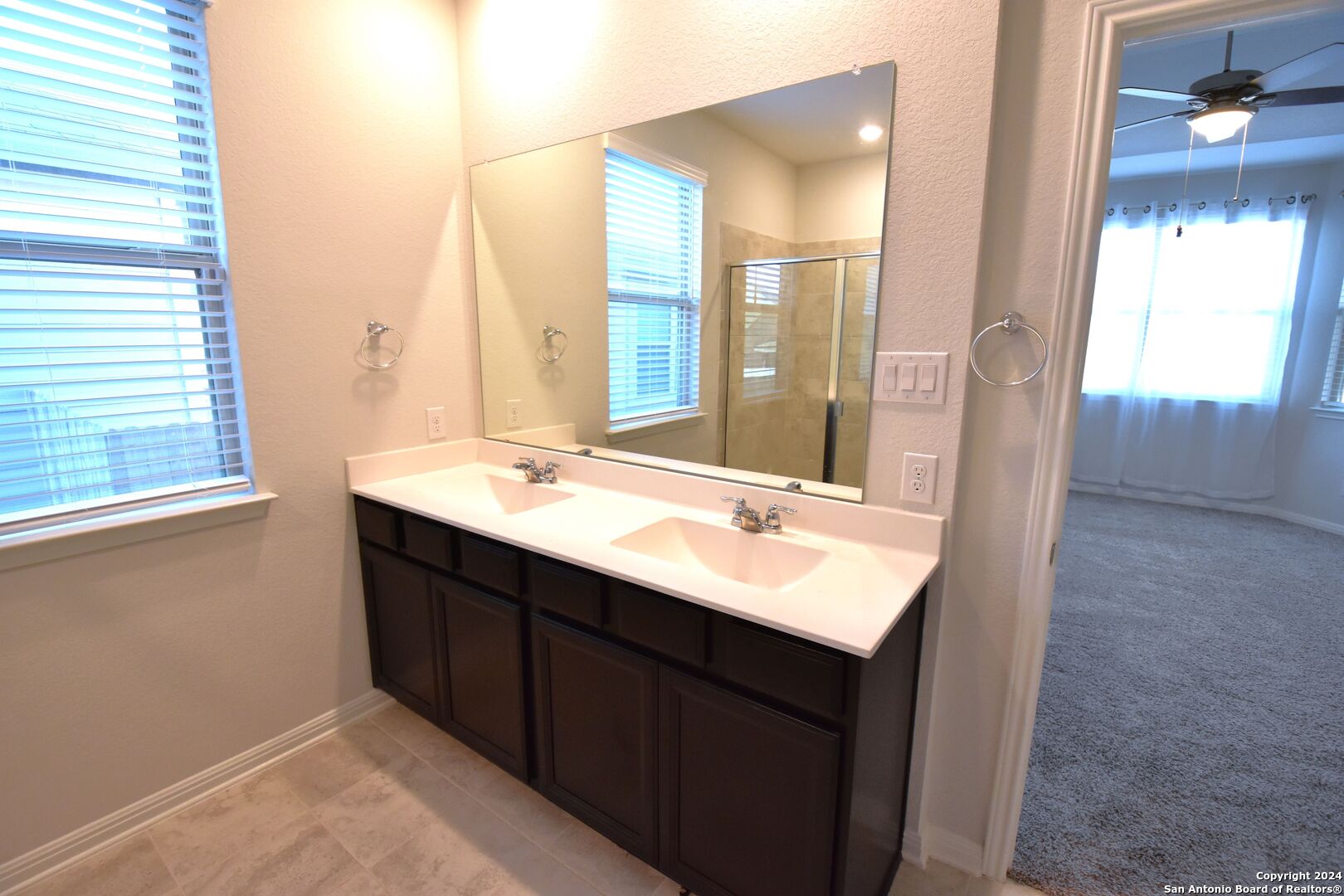 4923 Ranahan Pass St. Hedwig, TX 78152 - Photo 19 of 29 a bathroom with a double vanity sink and mirror