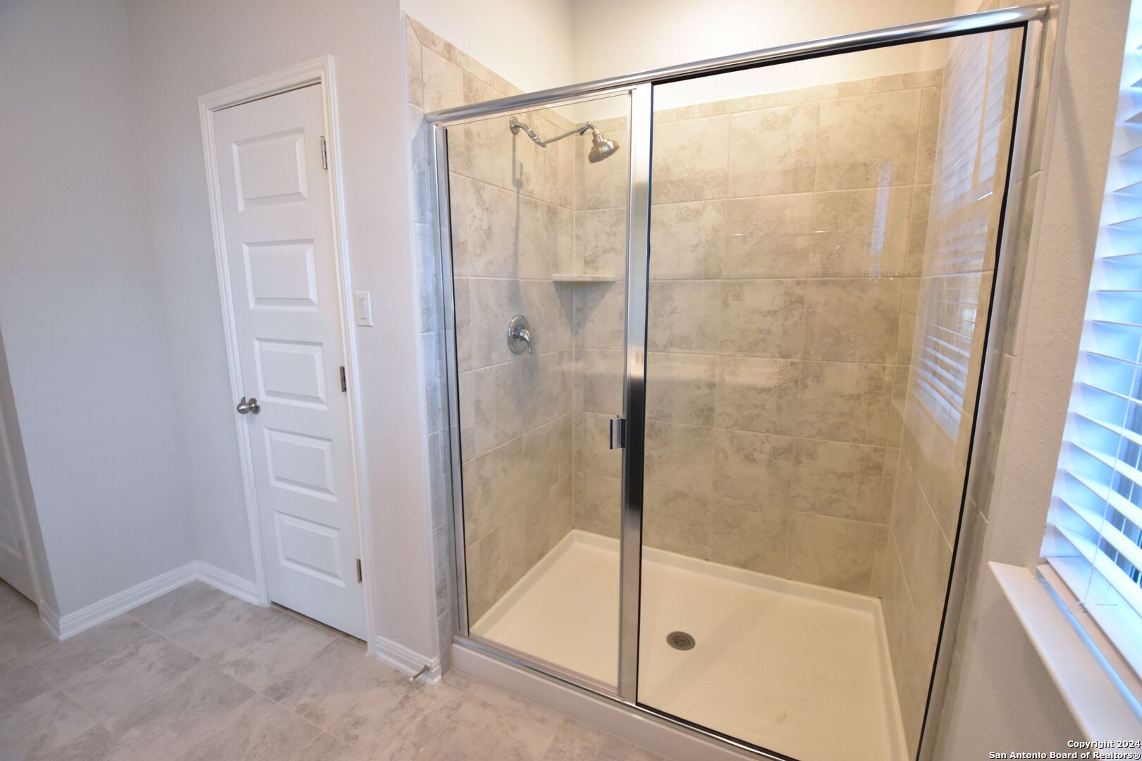4923 Ranahan Pass St. Hedwig, TX 78152 - Photo 20 of 29 a bathroom with a glass shower door