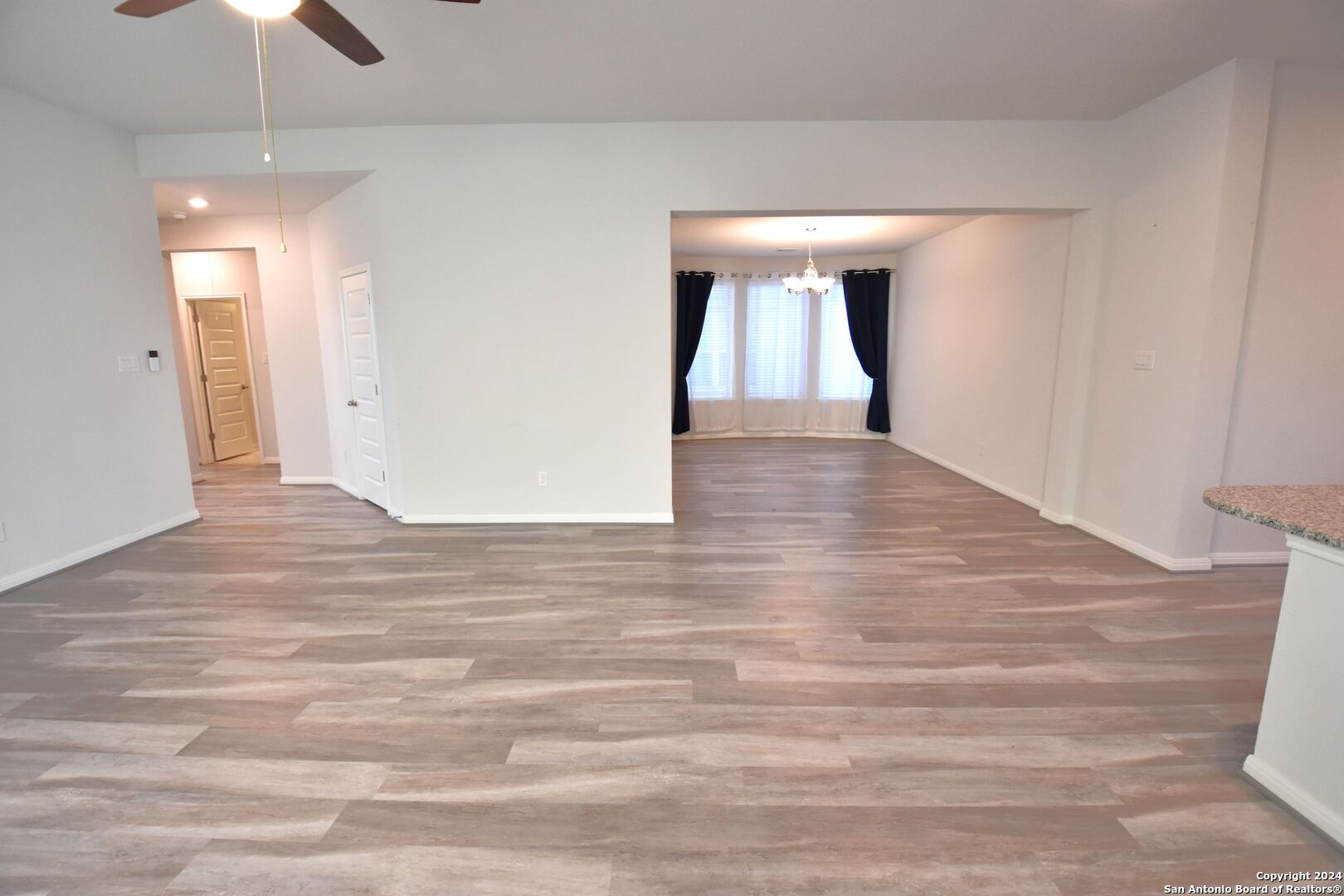 4923 Ranahan Pass St. Hedwig, TX 78152 - Photo 6 of 29 a view of a hallway with wooden floor and staircase