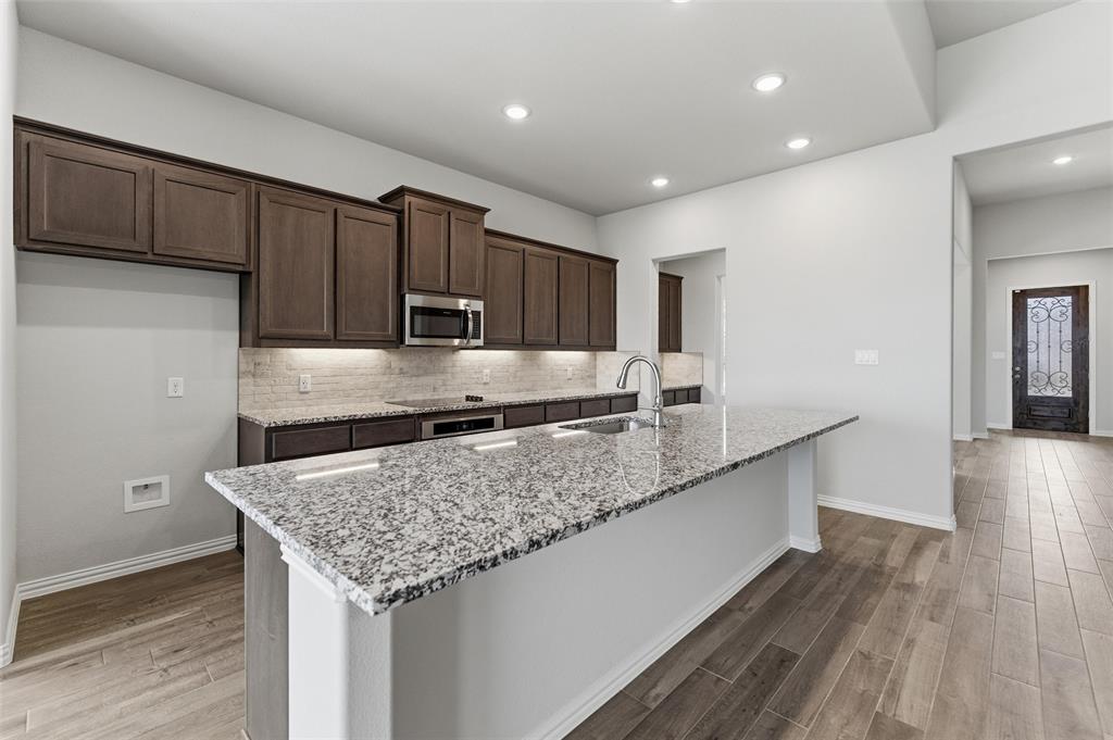 428 Guadalupe Lane Springtown, TX 76082 - Photo 24 of 29 a kitchen with stainless steel appliances granite countertop a sink stove and wooden floor