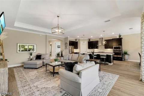 a living room with furniture kitchen view and a flat screen tv