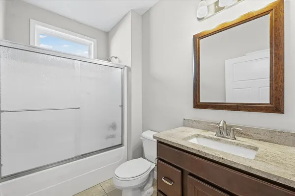a bathroom with a granite countertop tub sink and mirror