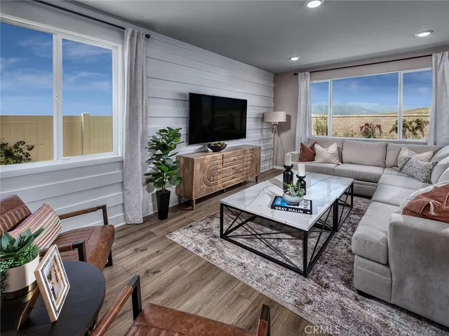a living room with furniture a flat screen tv and a large window