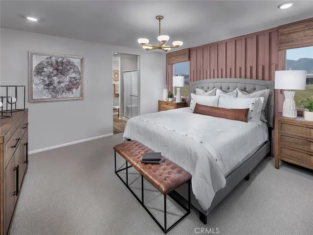 a bed room with a bed mirror and a chandelier