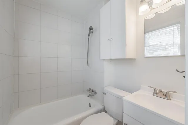 a white bath tub sitting next to a white sink and vanity