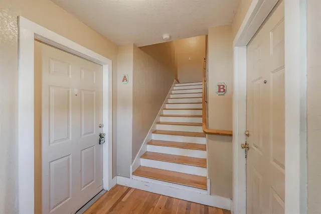 a view of a hallway with wooden floor and entryway