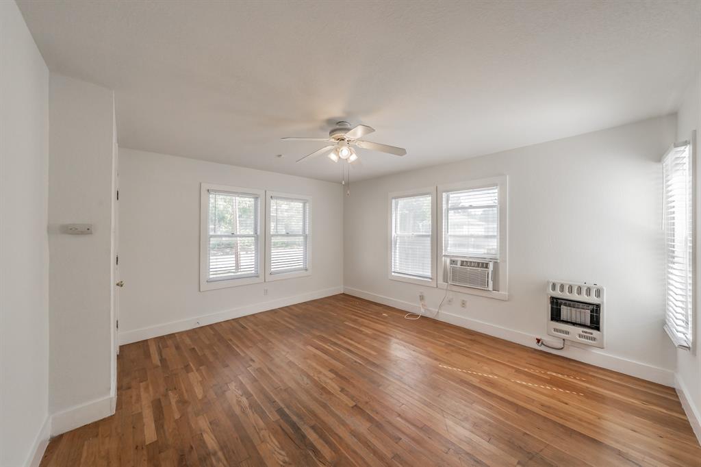 1509 Park Pl Avenue, Unit A Fort Worth, TX 76110 - Photo 4 of 13 a view of an empty room with a window and wooden floor
