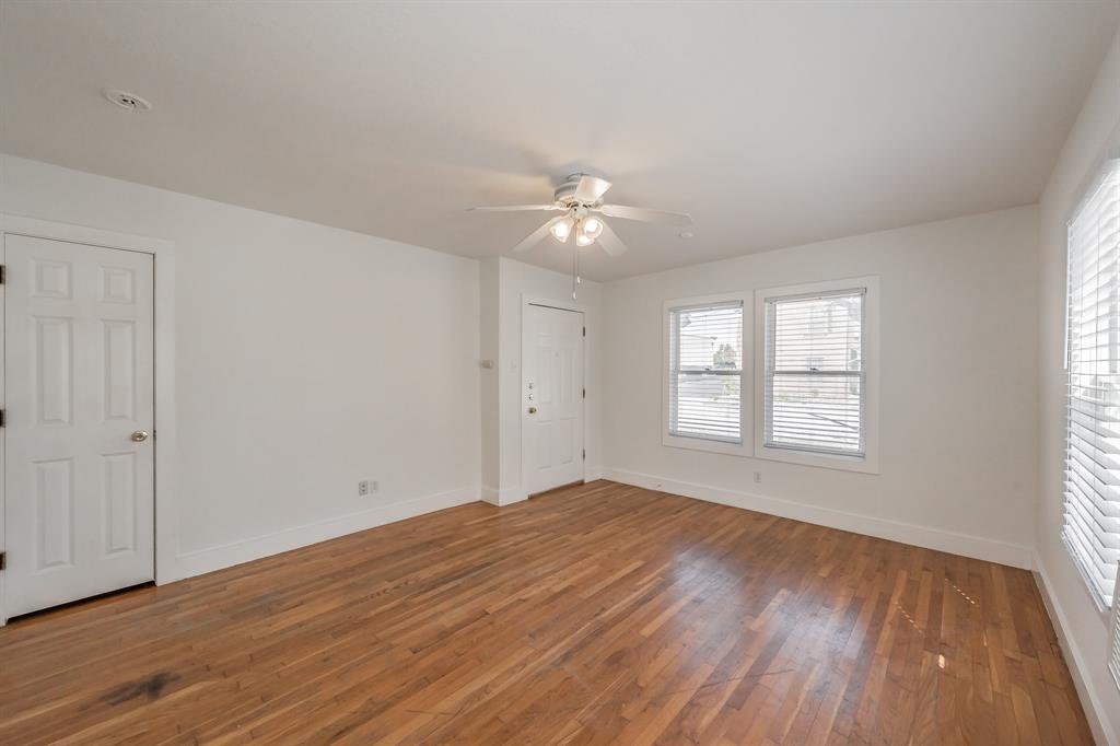 1509 Park Pl Avenue, Unit A Fort Worth, TX 76110 - Photo 5 of 13 a view of an empty room with wooden floor and a window