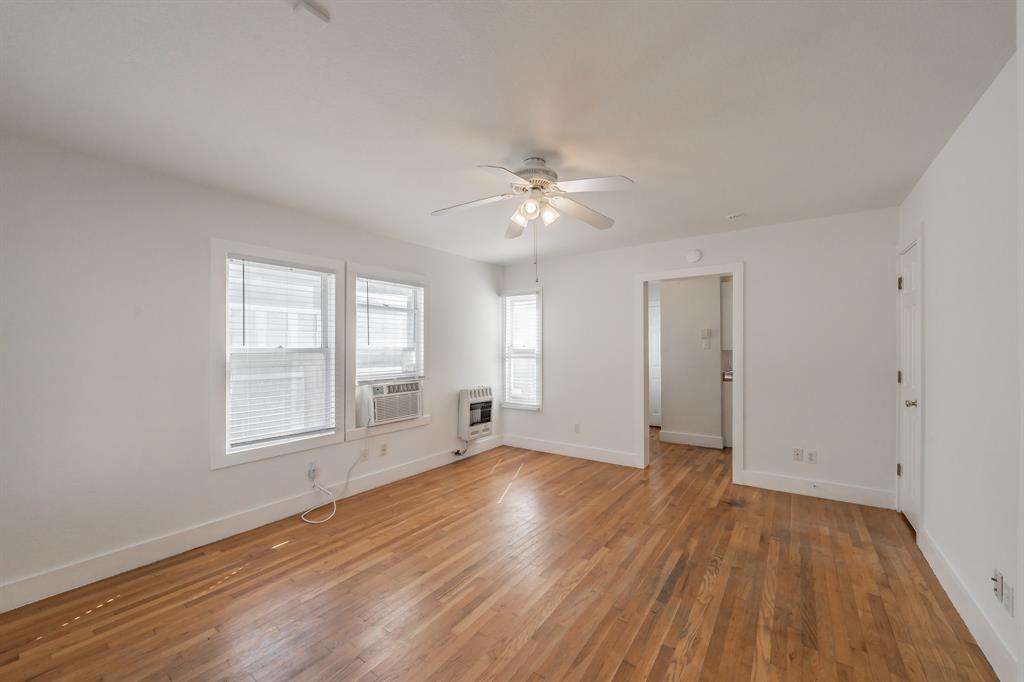 1509 Park Pl Avenue, Unit A Fort Worth, TX 76110 - Photo 6 of 13 an empty room with wooden floor and windows