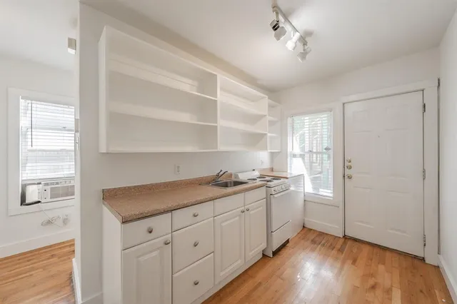 a kitchen with a sink cabinets and wooden floor