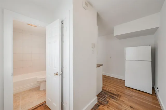 a view of a hallway with wooden floor and closet