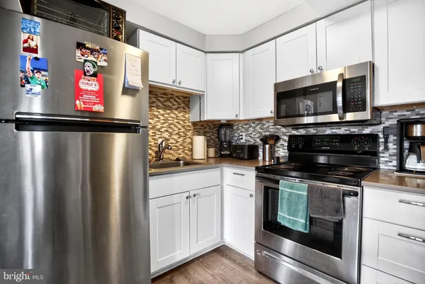 a kitchen with stainless steel appliances a refrigerator stove microwave and sink