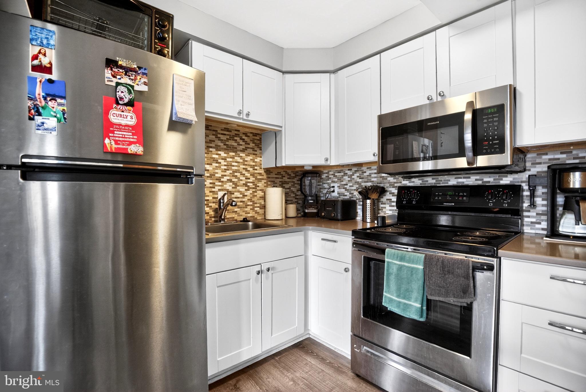 4401 Manayunk Avenue Philadelphia, PA 19128 - Photo 16 of 25 a kitchen with stainless steel appliances a refrigerator stove microwave and sink