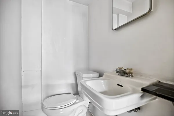 a bathroom with a sink a toilet and a mirror