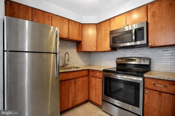 a kitchen with stainless steel appliances a refrigerator stove and microwave