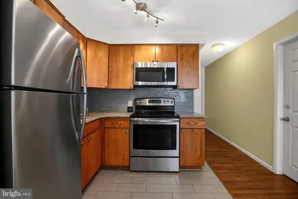 a kitchen with stainless steel appliances granite countertop a refrigerator and a stove top oven
