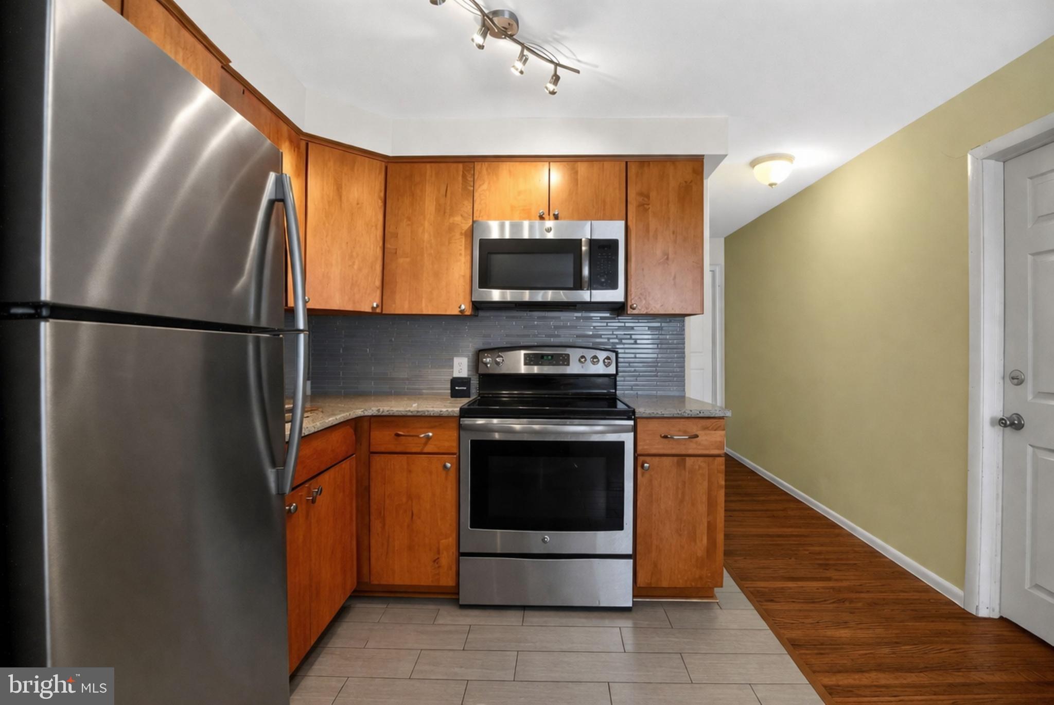 4401 Manayunk Avenue Philadelphia, PA 19128 - Photo 10 of 25 a kitchen with stainless steel appliances granite countertop a refrigerator and a stove top oven