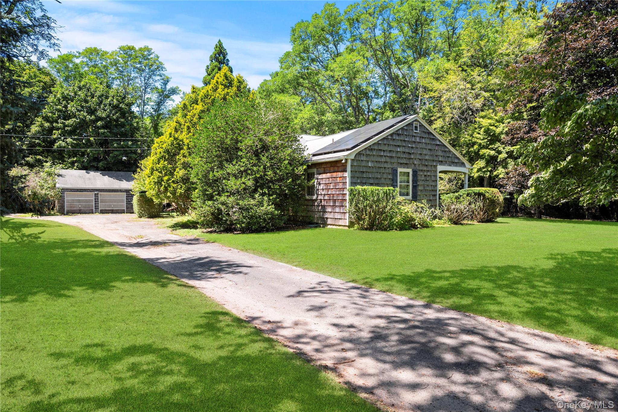 26 South Menantic Road Shelter Island, NY 11964 - Photo 1 of 46 View of front facade with a driveway leading to a two car garage