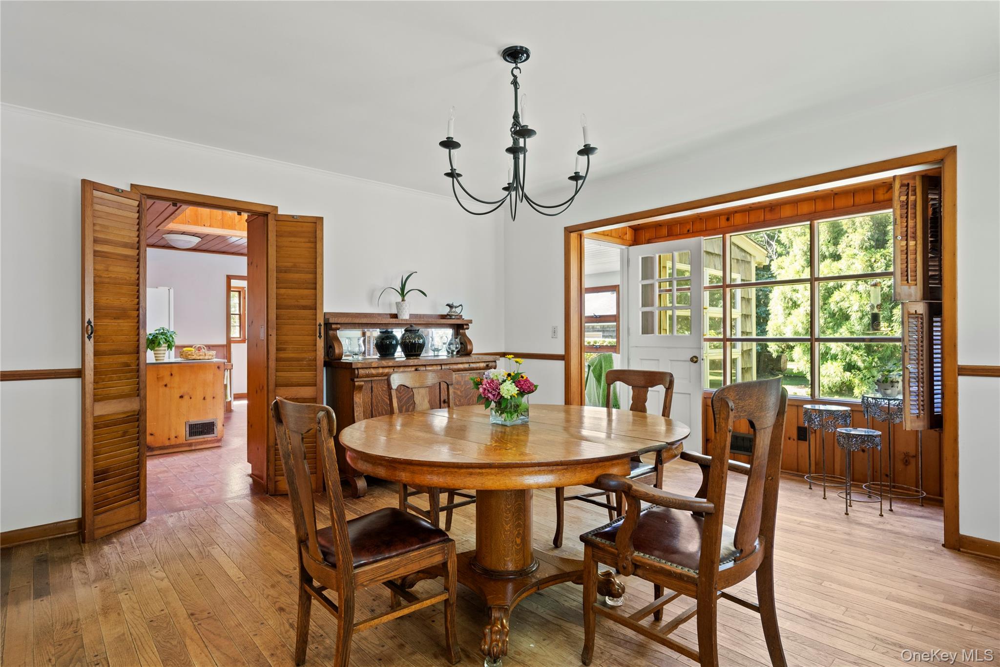 26 South Menantic Road Shelter Island, NY 11964 - Photo 15 of 49 a dining room with furniture wooden floor a rug a potted plant and a chandelier