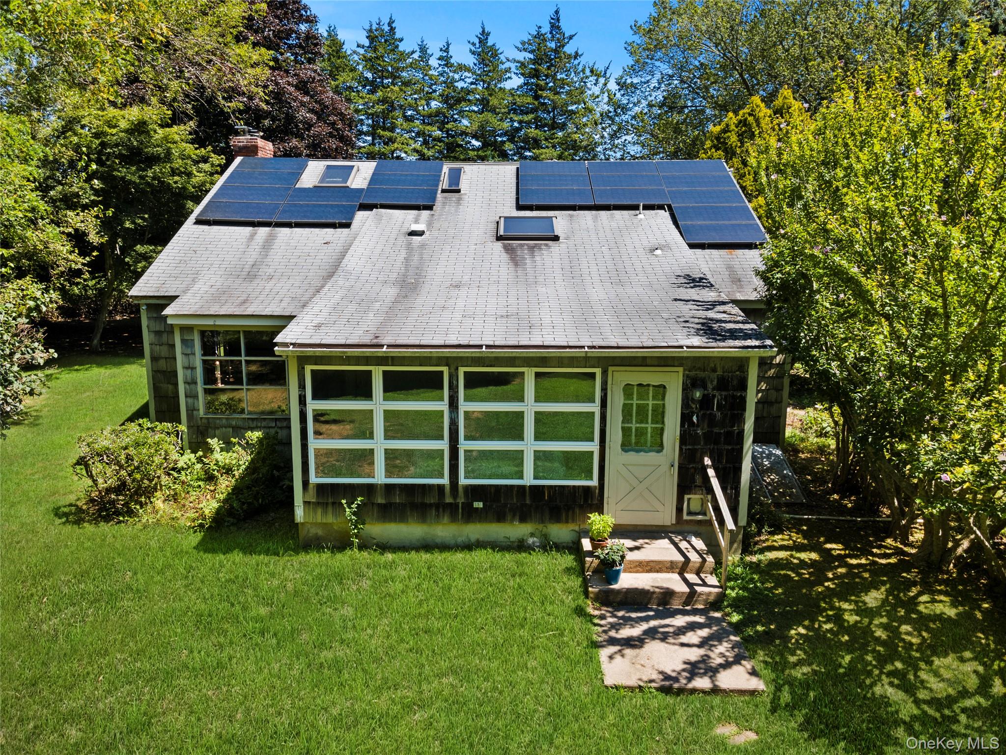 26 South Menantic Road Shelter Island, NY 11964 - Photo 29 of 42 a front view of a house with a garden and plants