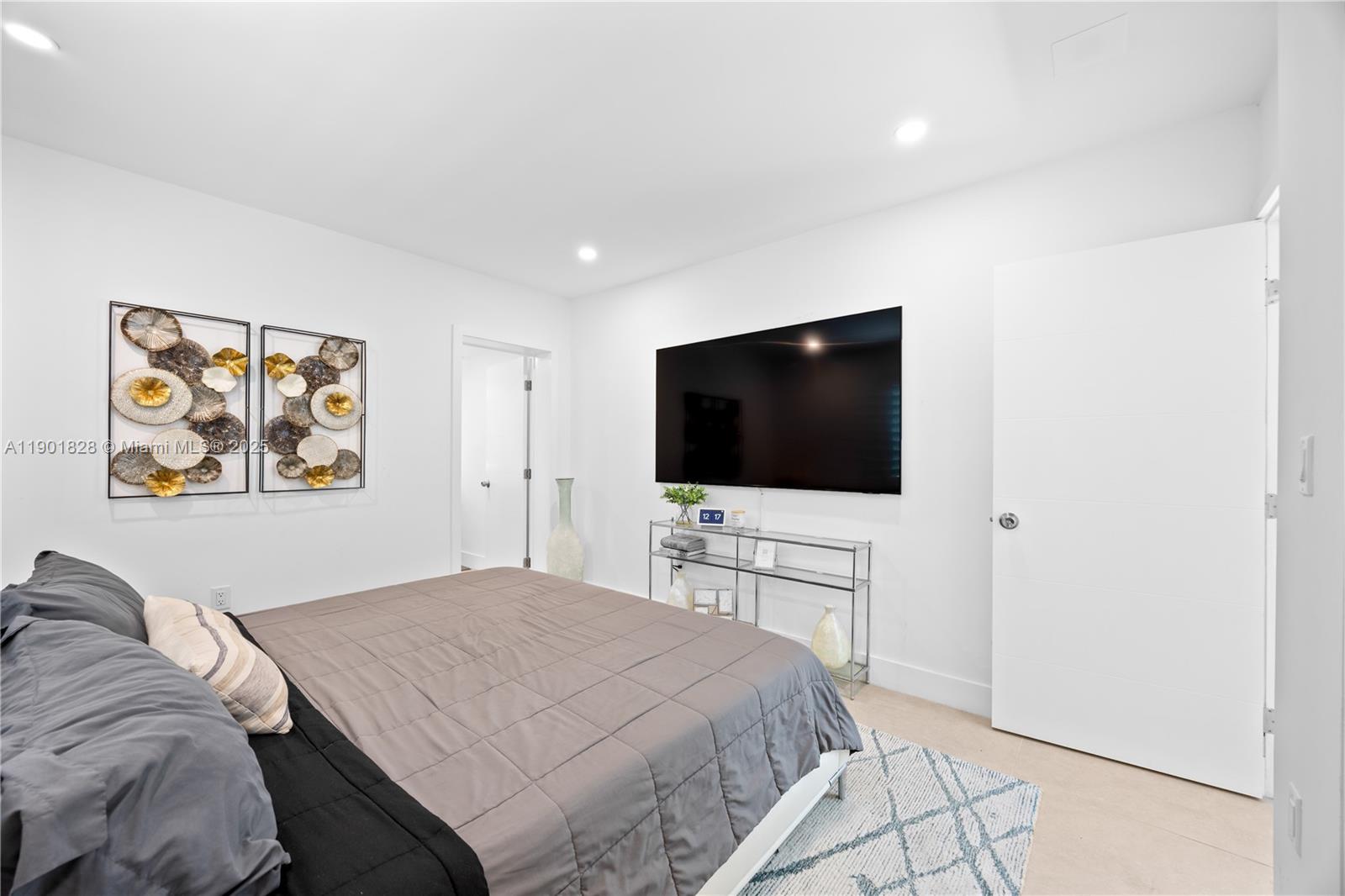 11 Northwest 45th Street Miami, FL 33127 - Photo 13 of 28 a bedroom with a bed and a flat screen tv