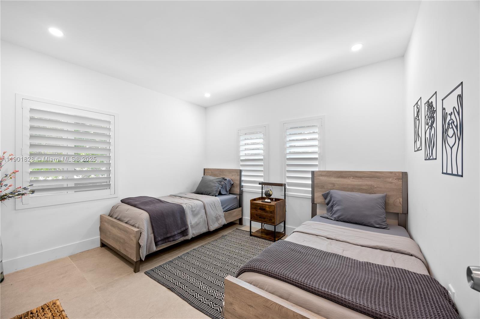 11 Northwest 45th Street Miami, FL 33127 - Photo 16 of 28 a spacious bedroom with two beds and a large window