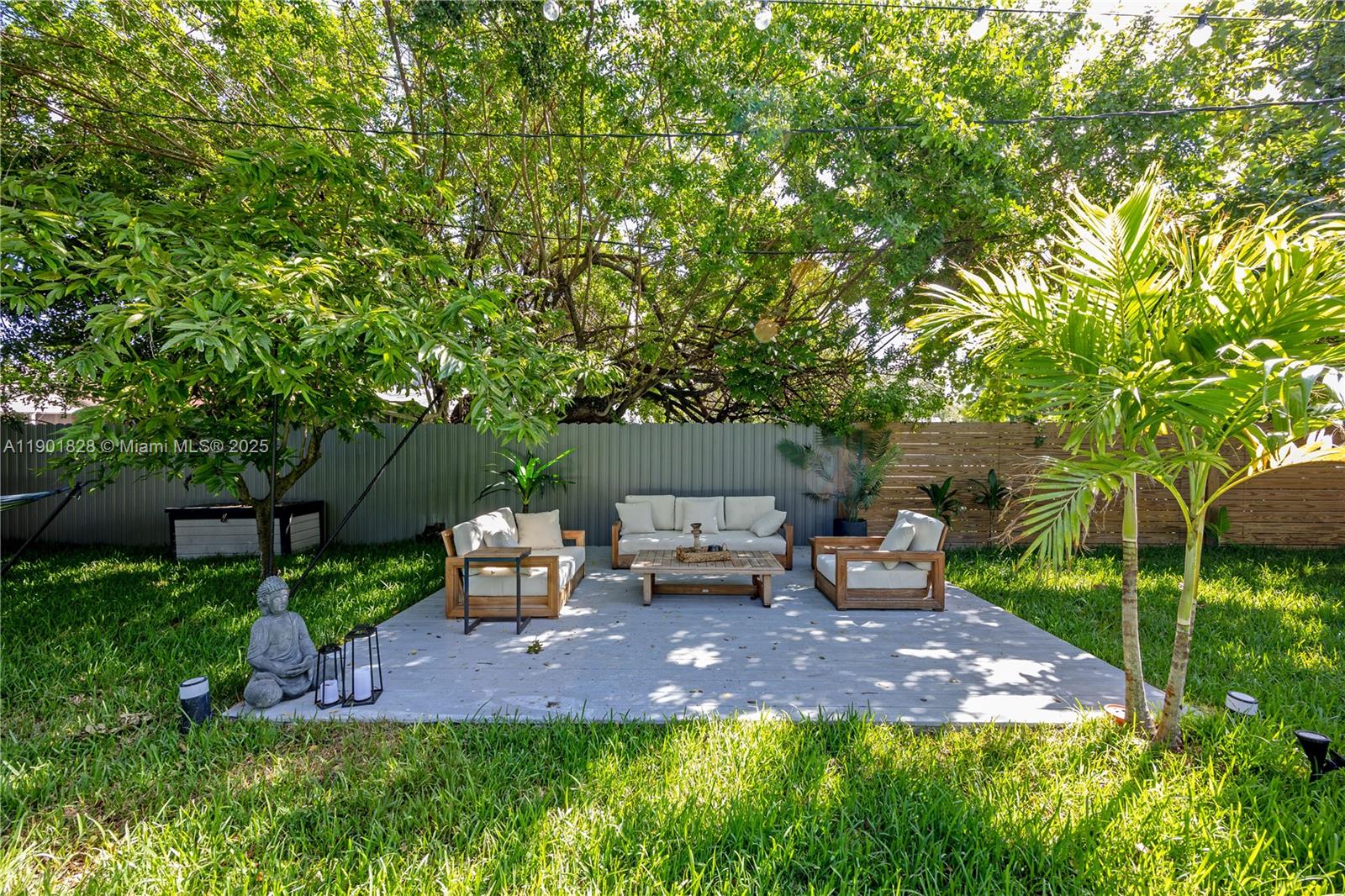11 Northwest 45th Street Miami, FL 33127 - Photo 3 of 28 a view of a backyard with lawn chairs under a large tree