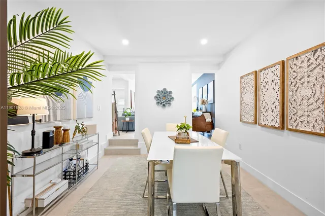 a dining room with furniture and a potted plant
