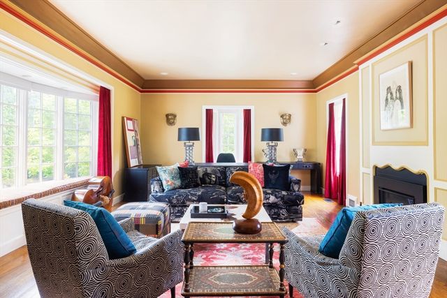 a living room with furniture fireplace and large windows